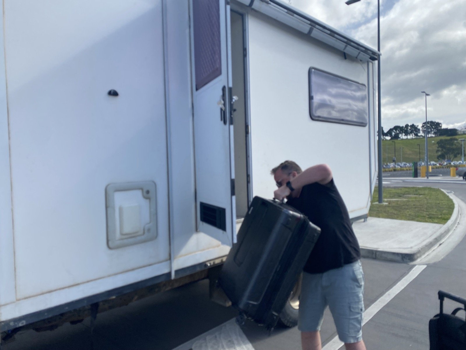 Shan loading a wheeled bag into the camper
